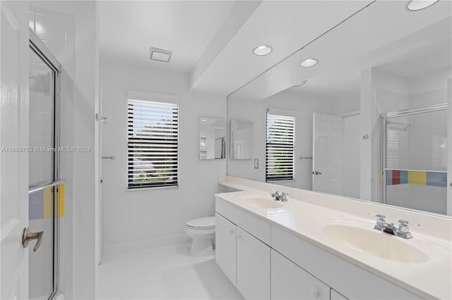 bathroom with vanity, toilet, and a shower with door