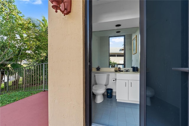 bathroom with tile patterned flooring, vanity, and toilet