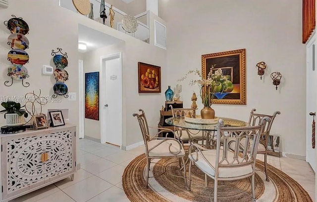 dining room with a towering ceiling and light tile patterned floors