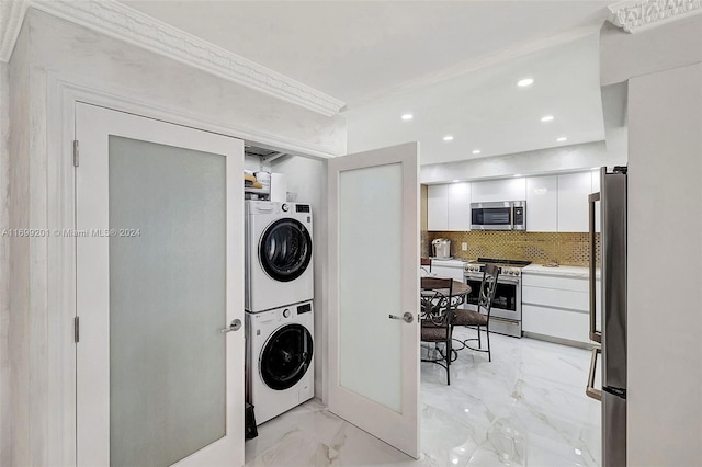 washroom featuring ornamental molding and stacked washer / drying machine