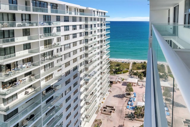 balcony with a water view and a view of the beach