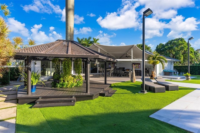 rear view of property with a gazebo and a yard