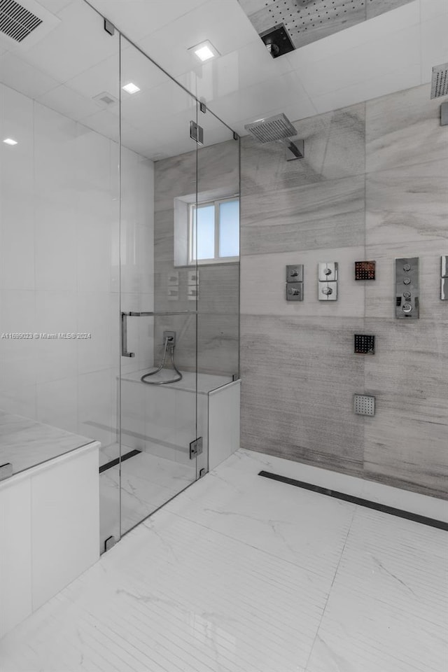 bathroom with a shower with door and tile walls