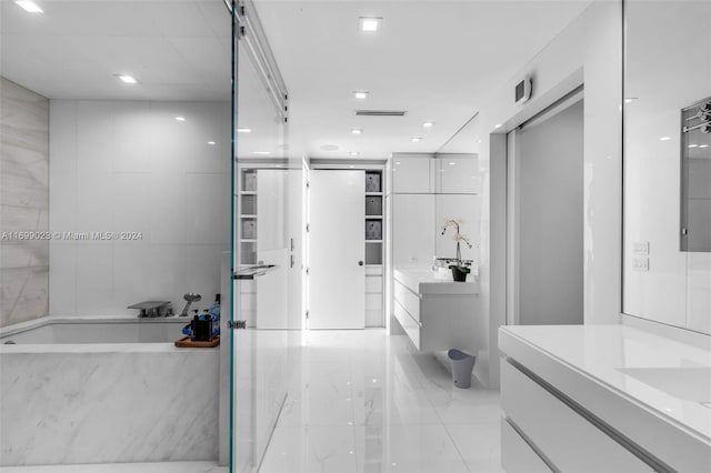 bathroom featuring a bath, vanity, and tile walls