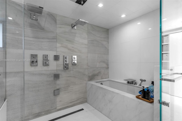 bathroom with tile walls and independent shower and bath