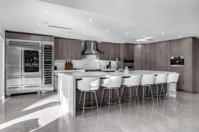 10 SW 124th Ave, Miami, FL 33184 - kitchen featuring wall chimney exhaust hood, modern cabinets, built in fridge, recessed lighting, and light countertops