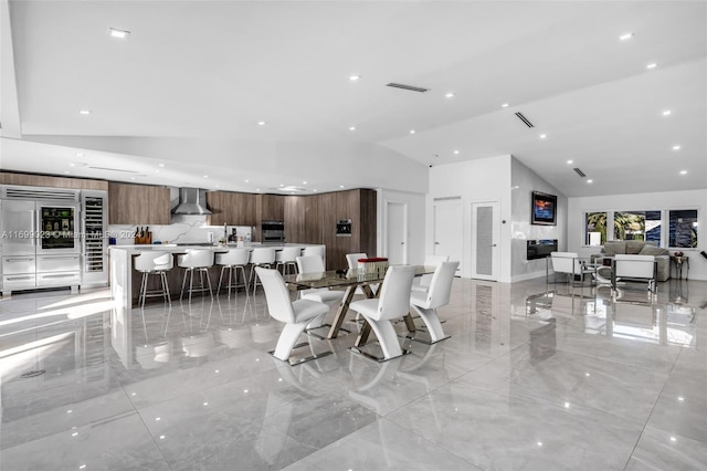 dining space with high vaulted ceiling