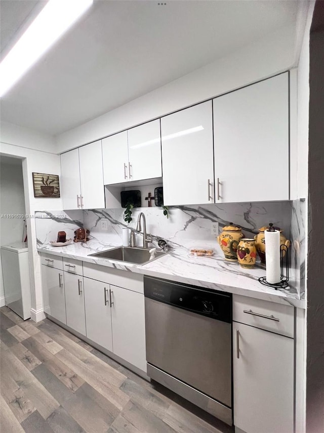 kitchen featuring tasteful backsplash, stainless steel dishwasher, sink, light hardwood / wood-style flooring, and white cabinets