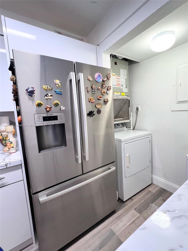 laundry area with washer / clothes dryer, electric panel, and light wood-type flooring