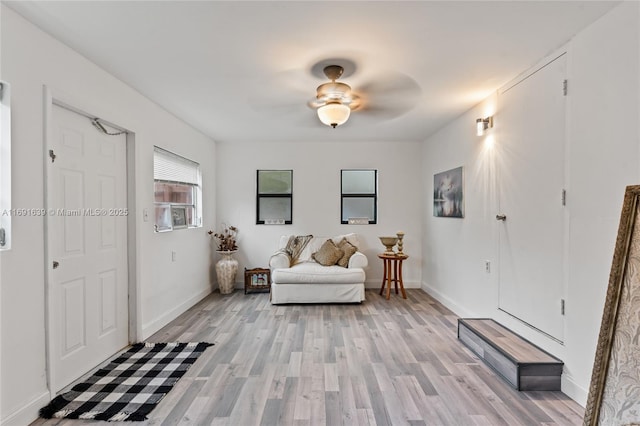 living area with ceiling fan and light wood-type flooring