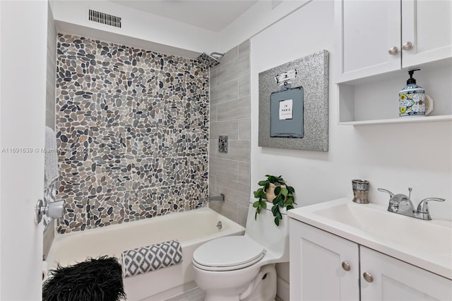 full bathroom with tiled shower / bath, vanity, and toilet