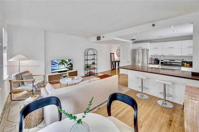 living room with light hardwood / wood-style flooring and sink