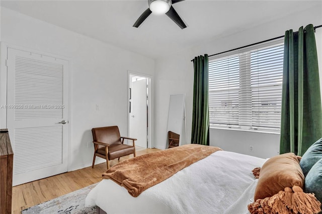 bedroom with ceiling fan, a closet, and light hardwood / wood-style floors