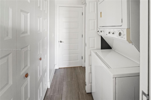 washroom featuring hardwood / wood-style flooring and stacked washer / drying machine