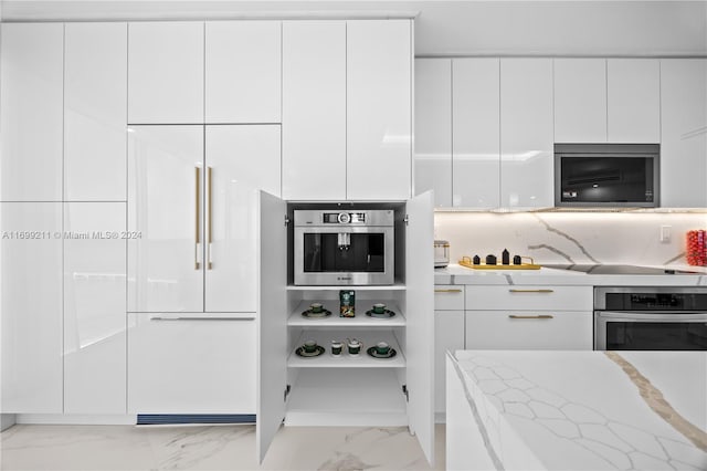 16445 Collins Ave Unit 1126, Sunny Isles Beach, FL 33160 - kitchen featuring appliances with stainless steel finishes, modern cabinets, marble look tiles, white cabinetry, and light stone counters