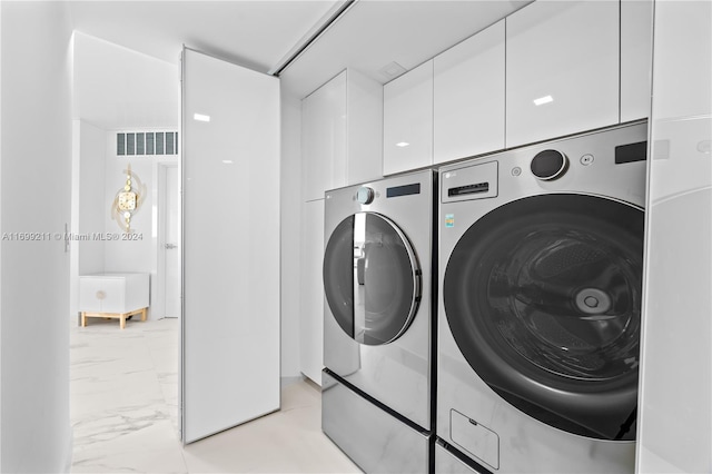 16445 Collins Ave Unit 1126, Sunny Isles Beach, FL 33160 - laundry room featuring washer and dryer, cabinet space, and light marble finish flooring