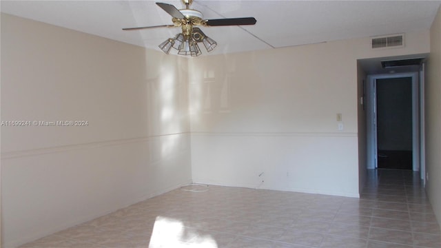 spare room with ceiling fan and tile patterned flooring