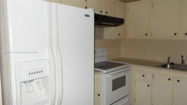 kitchen featuring cream cabinets, sink, extractor fan, and white appliances