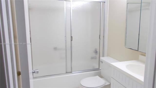 full bathroom featuring shower / bath combination with glass door, vanity, and toilet