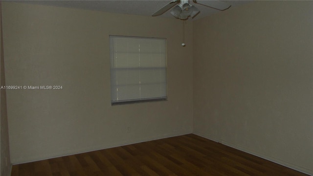 spare room featuring ceiling fan and dark wood-type flooring