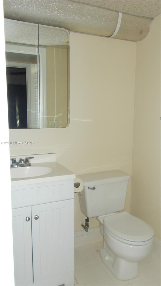 bathroom with tile patterned flooring, vanity, and toilet