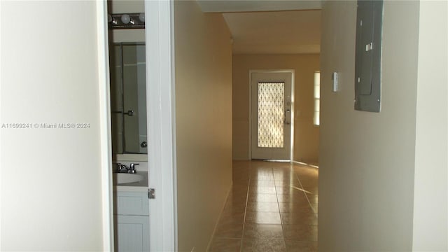 hall with electric panel and dark tile patterned floors