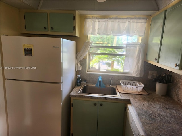 kitchen with white appliances, sink, decorative backsplash, and green cabinetry