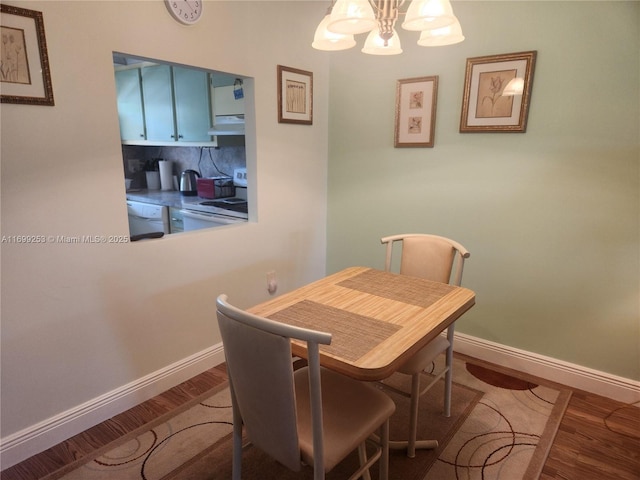 dining room with hardwood / wood-style floors and a notable chandelier