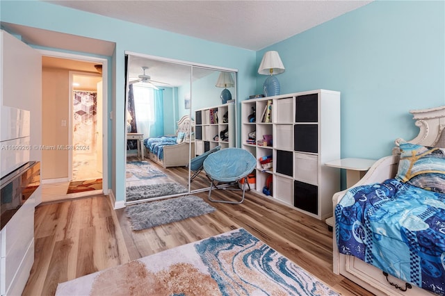 bedroom featuring a closet, a textured ceiling, and light hardwood / wood-style flooring