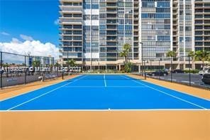 view of tennis court featuring basketball hoop