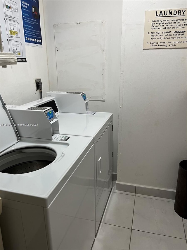 laundry area with independent washer and dryer and light tile patterned floors