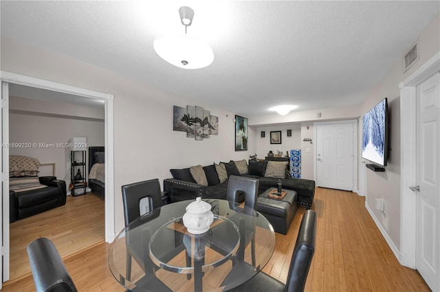 dining space featuring hardwood / wood-style floors and a textured ceiling