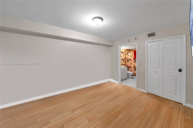 bedroom featuring a textured ceiling and light wood-type flooring