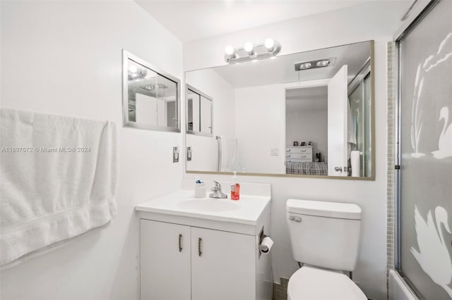 full bathroom featuring vanity, toilet, and combined bath / shower with glass door