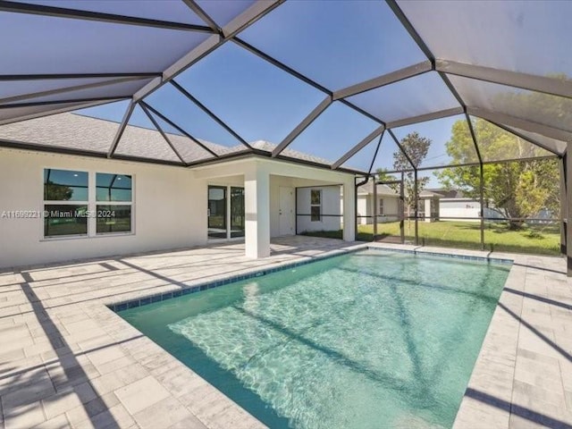 view of pool featuring glass enclosure and a patio area