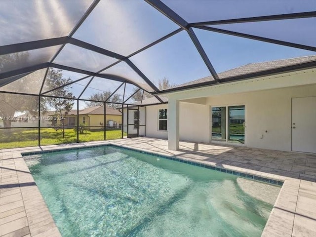 view of pool with glass enclosure and a patio