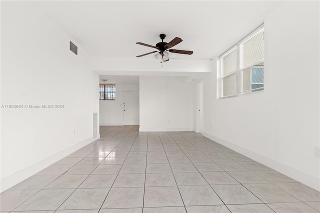 unfurnished room with light tile patterned floors, plenty of natural light, and ceiling fan