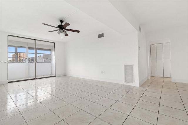 tiled spare room featuring ceiling fan