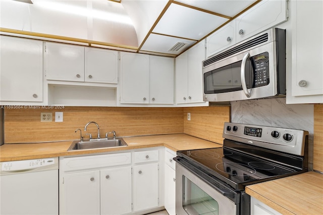 kitchen with white cabinets, decorative backsplash, sink, and appliances with stainless steel finishes