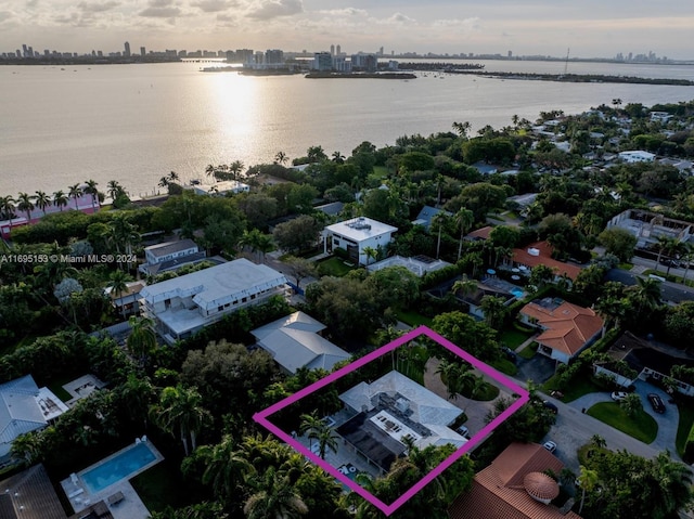 aerial view at dusk featuring a water view