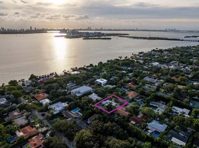 aerial view at dusk featuring a water view