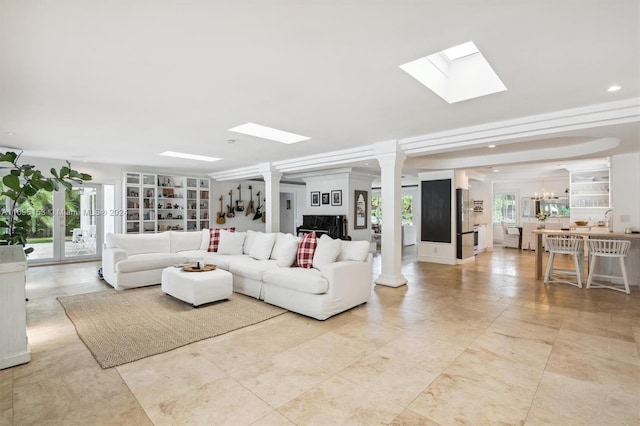 living room with an inviting chandelier and ornate columns