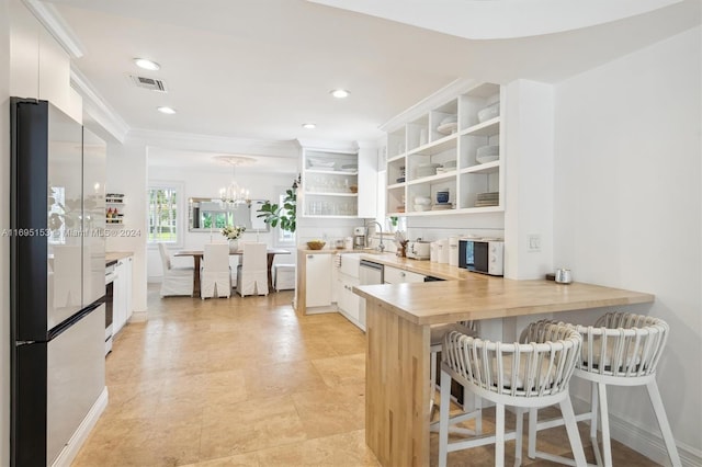 kitchen featuring white cabinetry, kitchen peninsula, pendant lighting, a kitchen bar, and appliances with stainless steel finishes