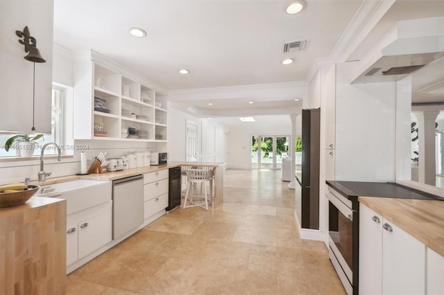 kitchen featuring white cabinetry, dishwasher, sink, a healthy amount of sunlight, and butcher block countertops