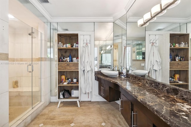 bathroom with vanity, a shower with shower door, and ornamental molding