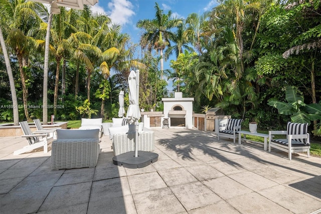 view of patio with an outdoor kitchen and exterior fireplace