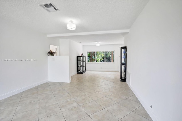 tiled empty room with a textured ceiling