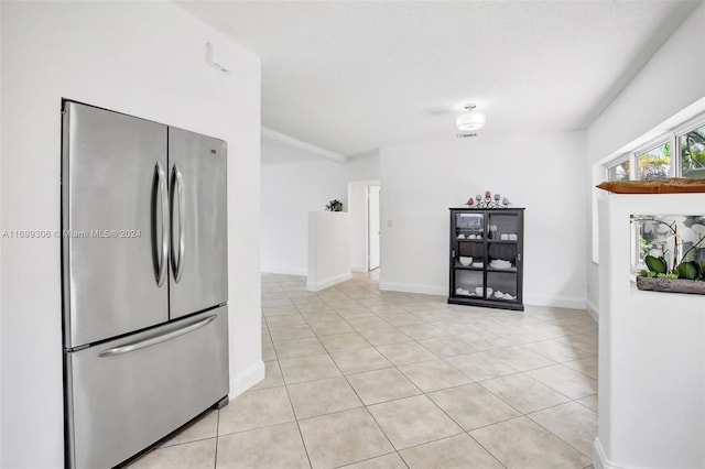 kitchen with light tile patterned floors, a textured ceiling, and stainless steel refrigerator