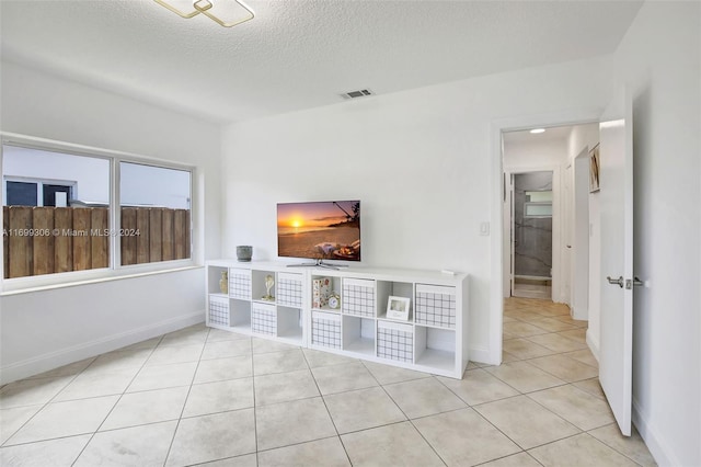 interior space with light tile patterned flooring and a textured ceiling