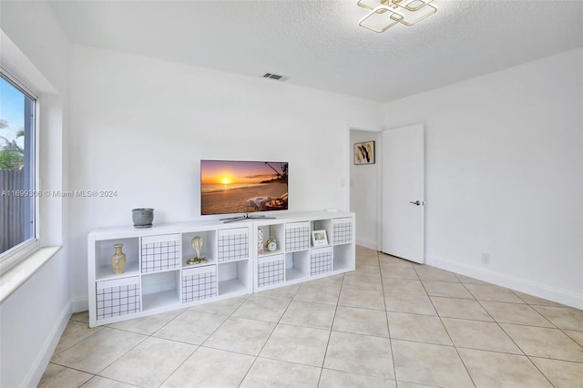 unfurnished living room with light tile patterned floors and a textured ceiling